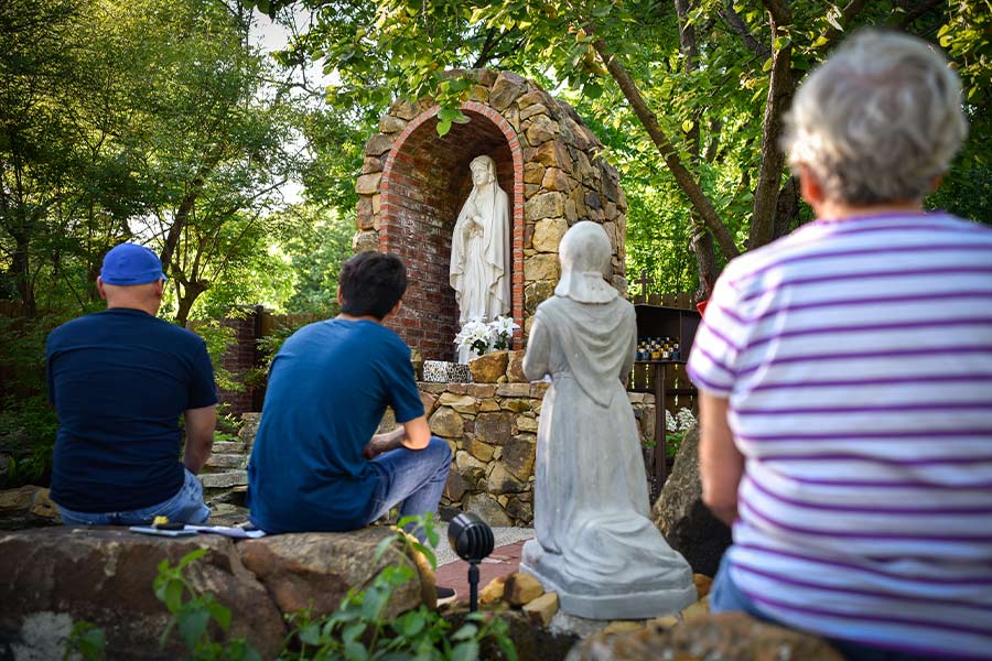 Parishioners pray the Rosary in the prayer garden of Our Lady of Lourdes Church in Mineral Wells. (NTC/Ben Torres)
