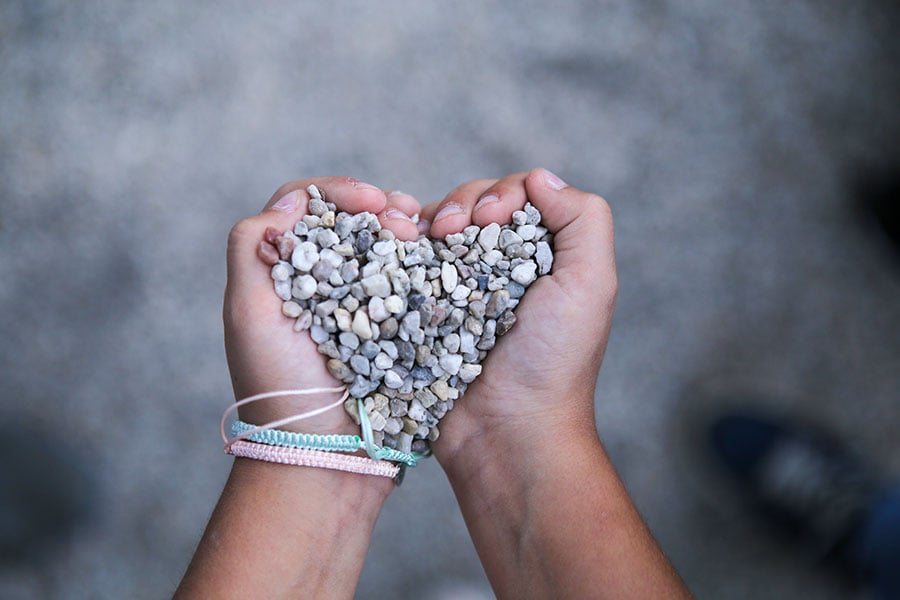 hands holding gravel heart