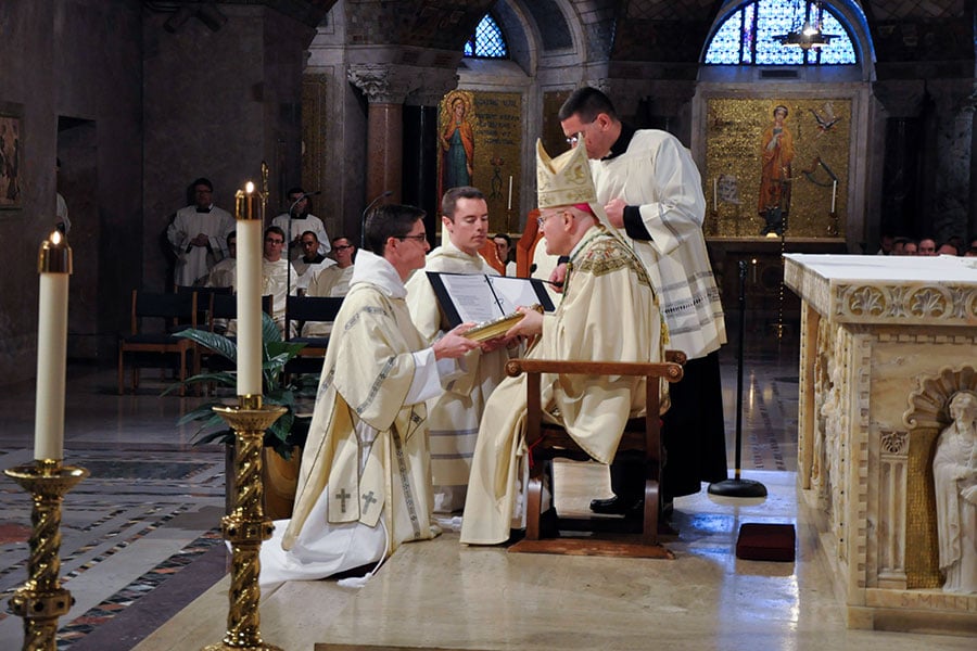 Deacon Titus receives the book of the Gospel